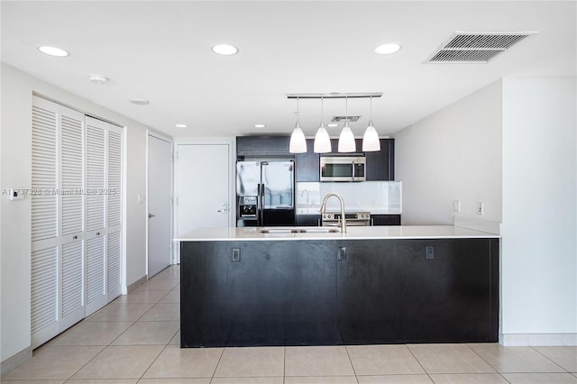 kitchen featuring light tile patterned floors, sink, stainless steel appliances, and pendant lighting