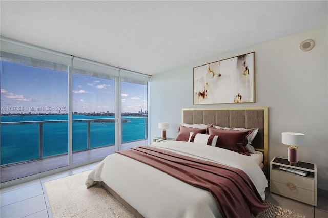 bedroom featuring light tile patterned floors, access to outside, and floor to ceiling windows