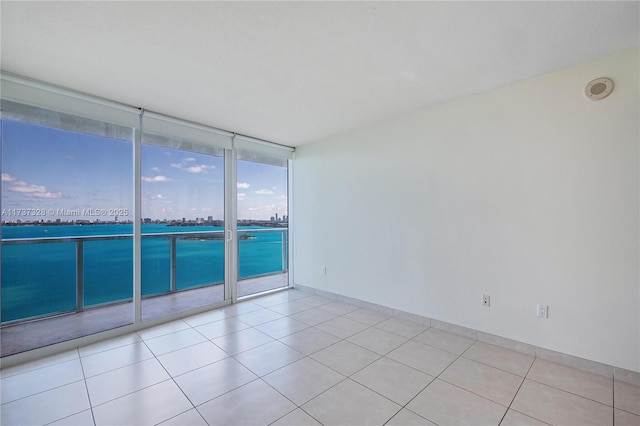 spare room featuring light tile patterned floors and floor to ceiling windows