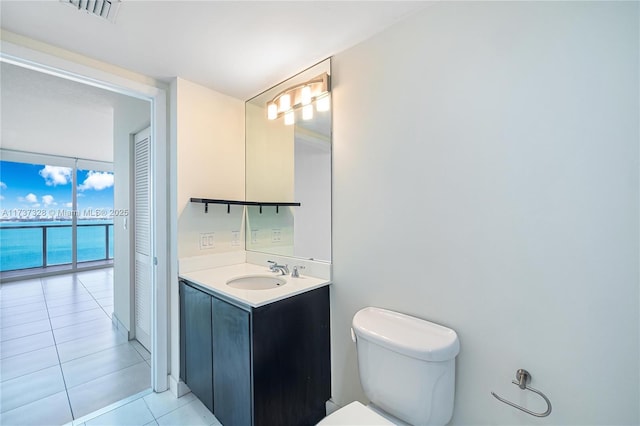 bathroom featuring toilet, vanity, and tile patterned flooring