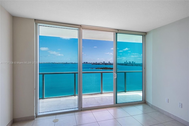 tiled empty room with a water view and floor to ceiling windows