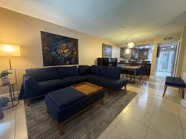 tiled living room featuring a textured ceiling