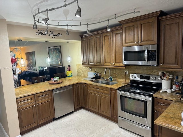 kitchen with sink, decorative light fixtures, kitchen peninsula, stainless steel appliances, and decorative backsplash