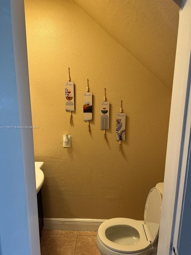 bathroom featuring toilet and tile patterned flooring