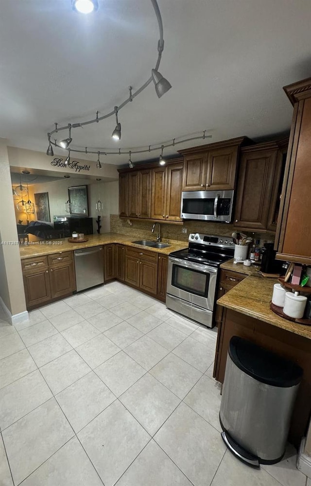 kitchen with light tile patterned flooring, appliances with stainless steel finishes, sink, and backsplash