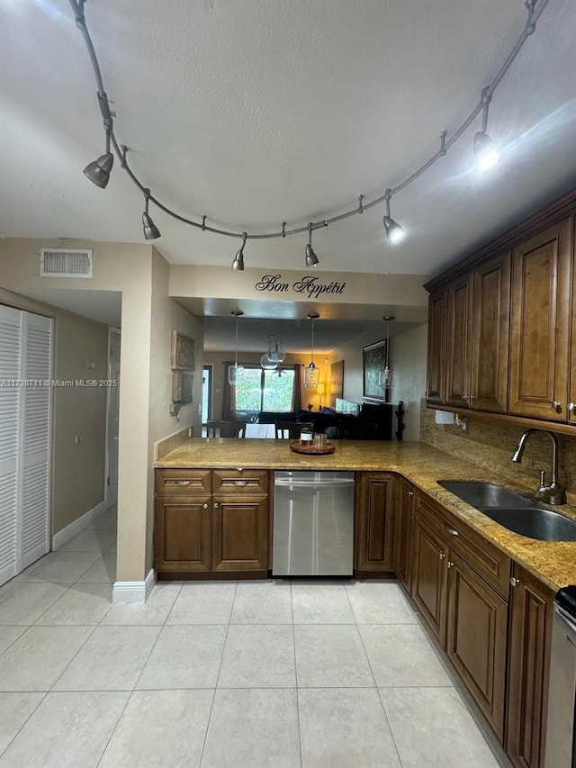 kitchen featuring sink, hanging light fixtures, light tile patterned floors, dishwasher, and kitchen peninsula