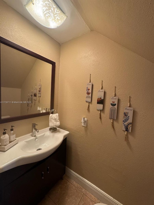 bathroom with tile patterned flooring, vanity, and lofted ceiling