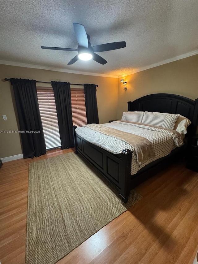 bedroom featuring hardwood / wood-style floors, ornamental molding, and a textured ceiling