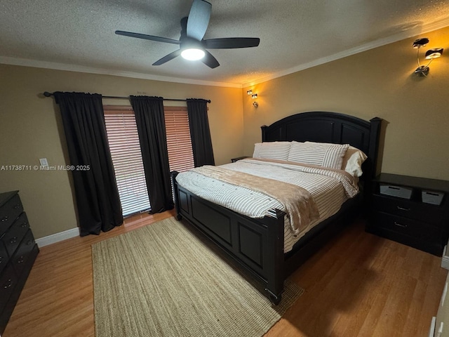 bedroom with hardwood / wood-style flooring, ornamental molding, ceiling fan, and a textured ceiling