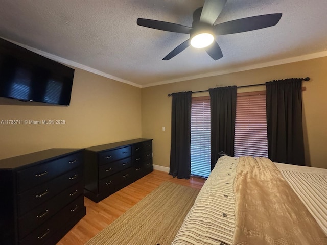 bedroom featuring ceiling fan, ornamental molding, a textured ceiling, and light wood-type flooring