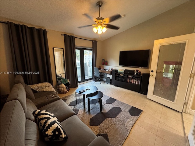 tiled living room featuring vaulted ceiling, ceiling fan, a textured ceiling, and french doors