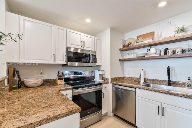 kitchen with stainless steel appliances, white cabinetry, and sink