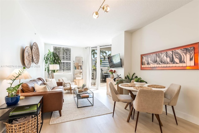 dining area with light hardwood / wood-style floors and a wall of windows