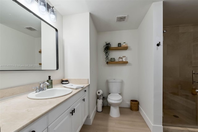 bathroom featuring vanity, tiled shower, and toilet