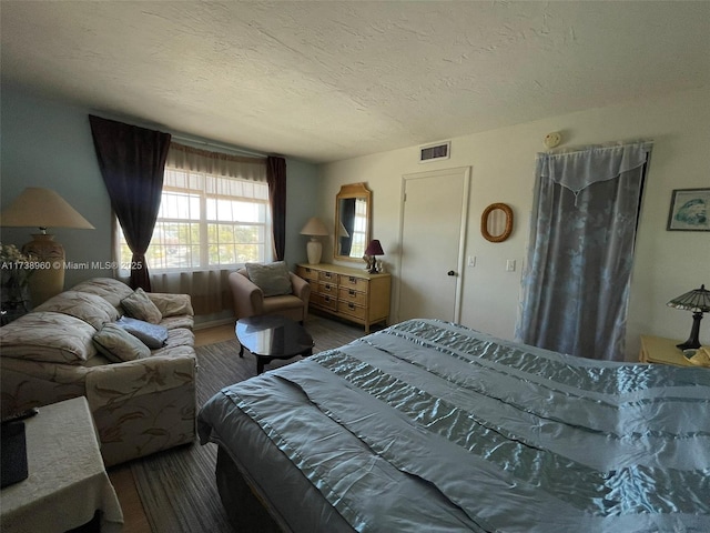 bedroom with hardwood / wood-style floors and a textured ceiling