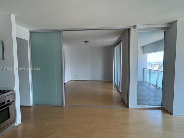 hall featuring a wall of windows and light wood-type flooring