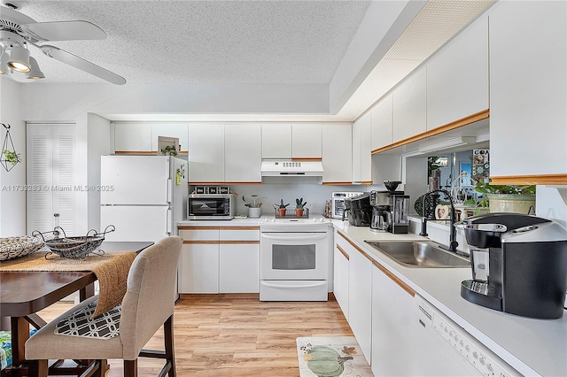 kitchen with sink, white appliances, light hardwood / wood-style floors, white cabinets, and a textured ceiling