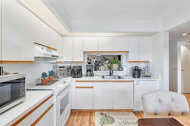 kitchen with sink, white appliances, white cabinetry, a textured ceiling, and light wood-type flooring