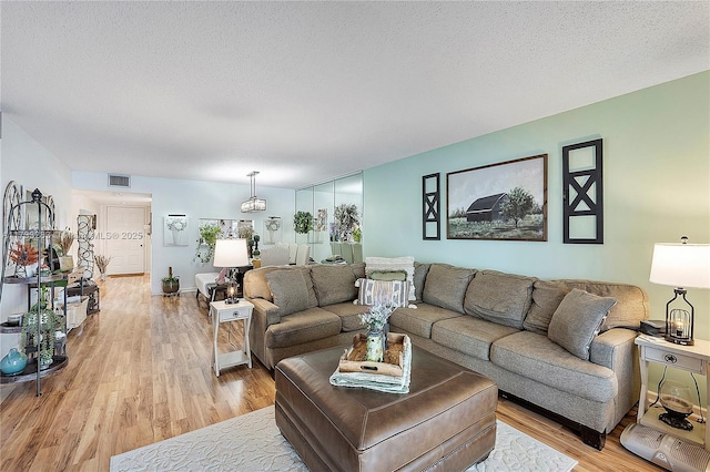 living room featuring a textured ceiling and light wood-type flooring