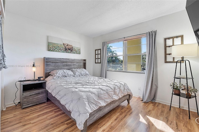 bedroom with wood-type flooring and a textured ceiling