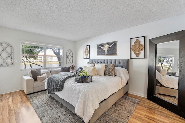 bedroom with hardwood / wood-style flooring and a textured ceiling