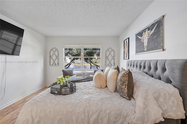 bedroom featuring hardwood / wood-style flooring and a textured ceiling