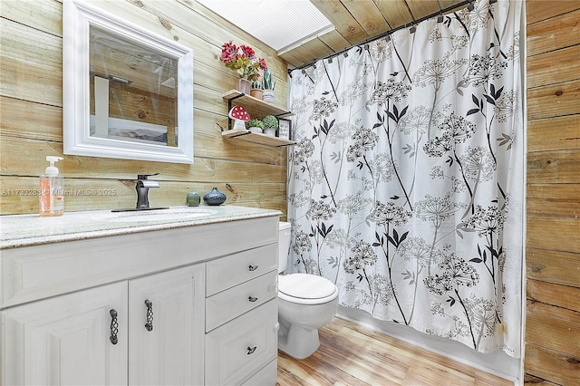 bathroom featuring toilet, wood ceiling, vanity, wooden walls, and hardwood / wood-style floors