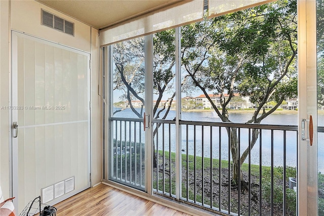 entryway featuring a water view and light hardwood / wood-style floors