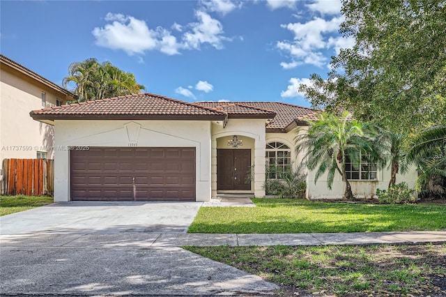 mediterranean / spanish-style home featuring a garage and a front lawn