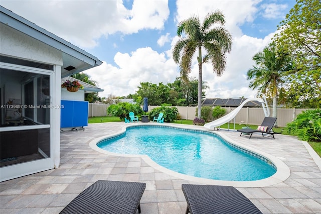 view of swimming pool featuring a water slide and a patio area