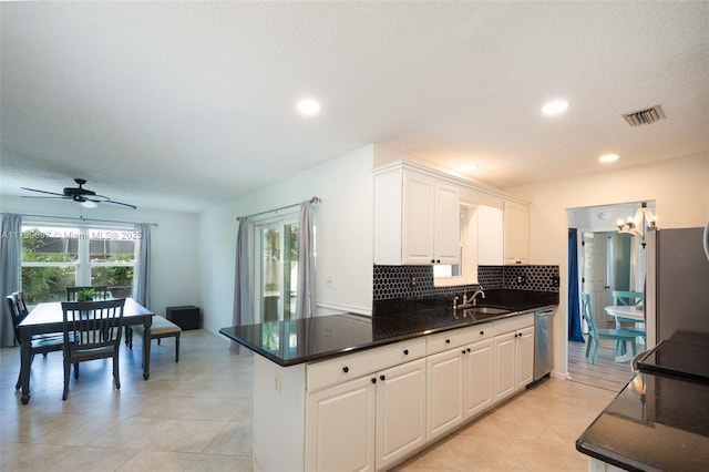 kitchen featuring white cabinetry, sink, stainless steel dishwasher, and decorative backsplash