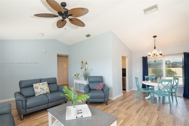 living room with light hardwood / wood-style flooring, ceiling fan with notable chandelier, and vaulted ceiling