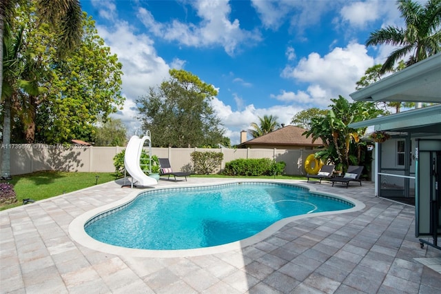 view of swimming pool featuring a water slide and a patio area