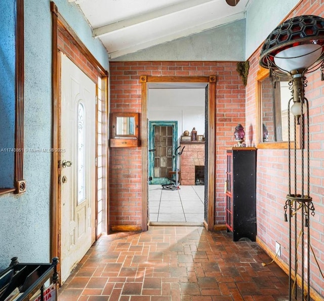 entrance foyer with brick wall and vaulted ceiling with beams