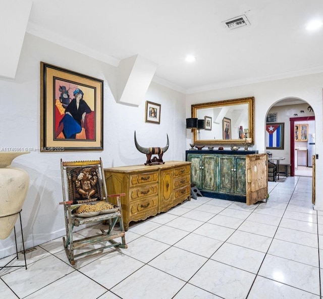 living area featuring ornamental molding and light tile patterned floors