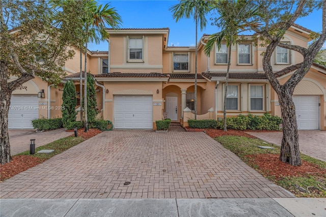 view of front of property with a tiled roof, decorative driveway, and stucco siding