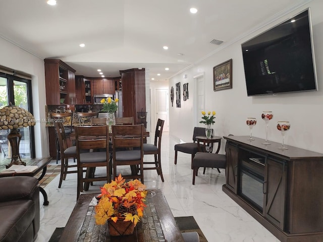 dining space featuring crown molding and vaulted ceiling