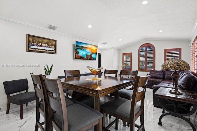 dining area with ornamental molding and lofted ceiling