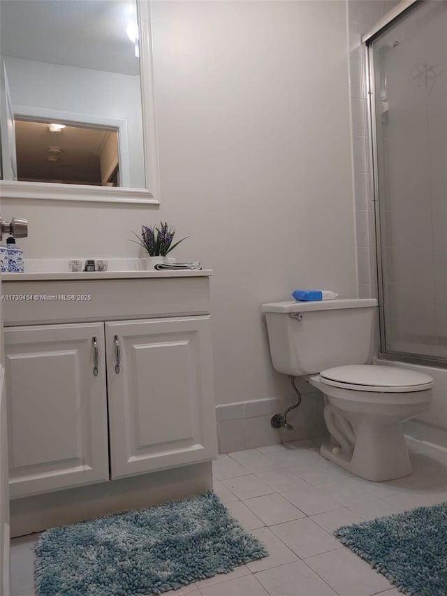 full bathroom featuring enclosed tub / shower combo, vanity, tile patterned flooring, and toilet