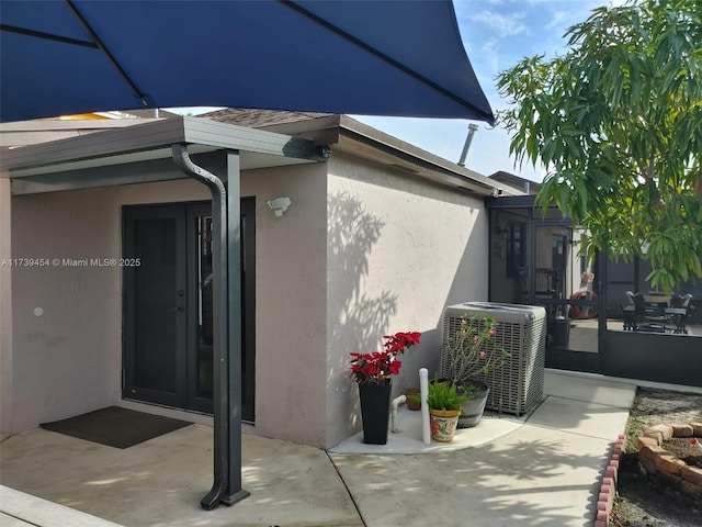 view of side of home with a patio area and central air condition unit