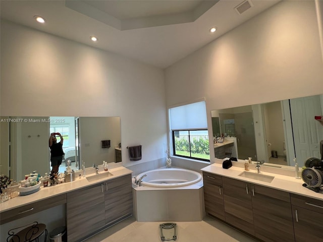 bathroom featuring vanity, shower with separate bathtub, a towering ceiling, and tile patterned floors