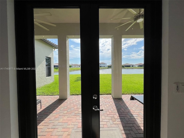 entryway featuring french doors, ceiling fan, and a water view