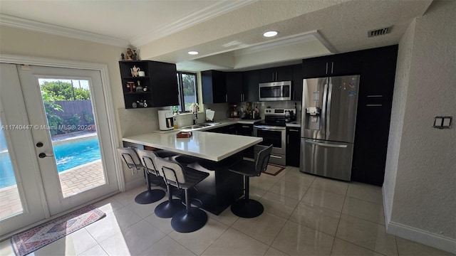 5051 NE 6th Ave, Deerfield Beach, FL 33064 - kitchen with sink, a breakfast bar area, stainless steel appliances, ornamental molding, and kitchen peninsula