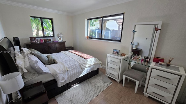 5051 NE 6th Ave, Deerfield Beach, FL 33064 - bedroom featuring multiple windows, crown molding, and light hardwood / wood-style flooring