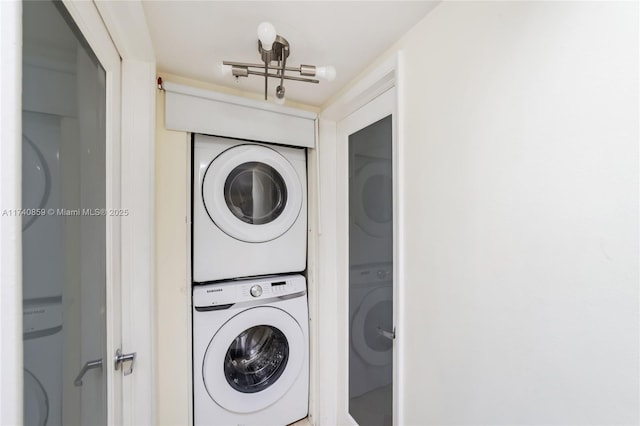 clothes washing area featuring stacked washer and clothes dryer