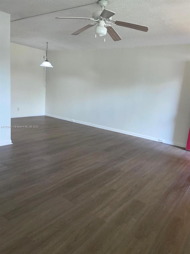 unfurnished room with ceiling fan, a textured ceiling, and dark hardwood / wood-style flooring