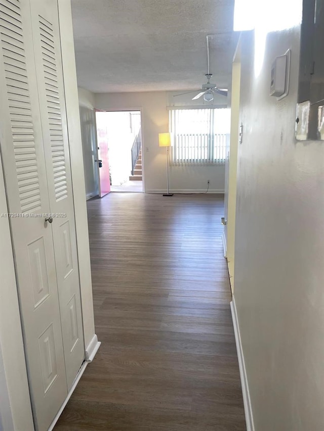 corridor featuring dark hardwood / wood-style flooring and a textured ceiling