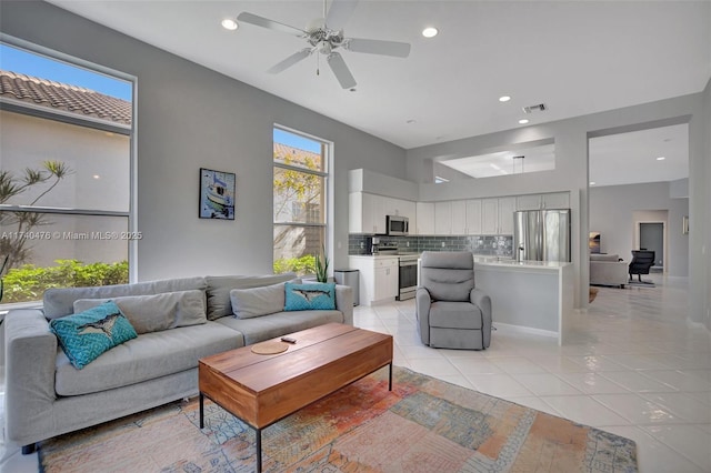 living room featuring light tile patterned floors, plenty of natural light, and ceiling fan