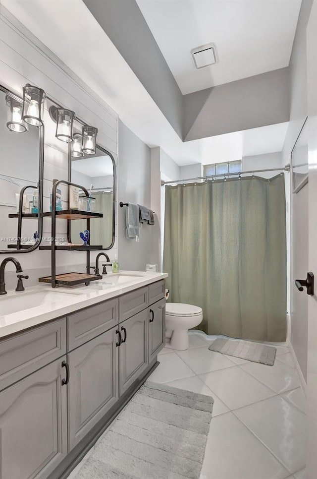 bathroom featuring tile patterned floors, vanity, toilet, and curtained shower