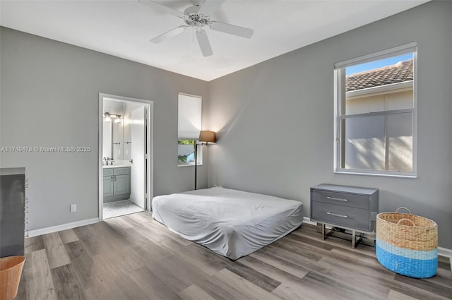 bedroom with ceiling fan, ensuite bath, sink, and light hardwood / wood-style floors